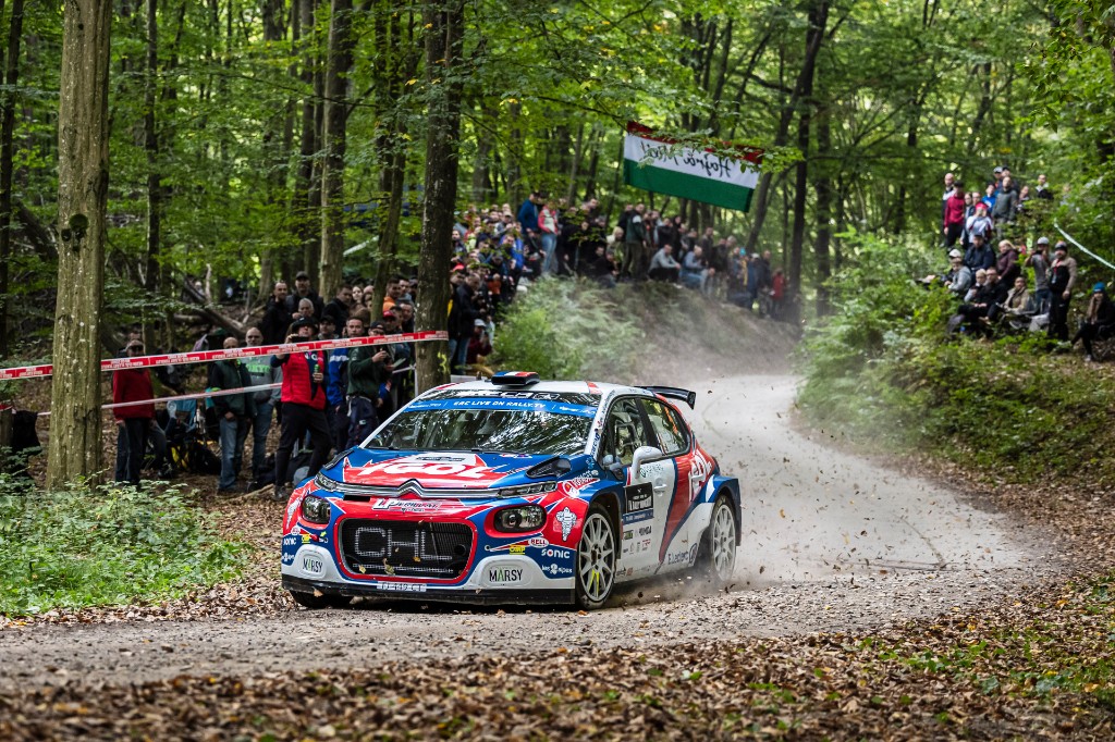Citroën Rally2 car through a forest stage lined with spectators